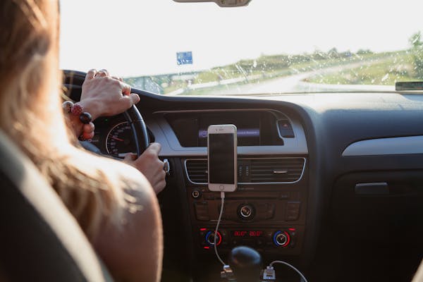 Person driving car steering wheel