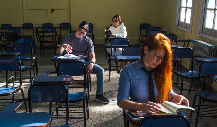 Lernende sitzen an Tischen in einem hellen Klassenzimmer