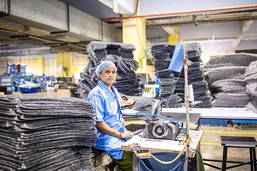 Arbeiterin bedient eine Maschine in einer Fabrikhalle